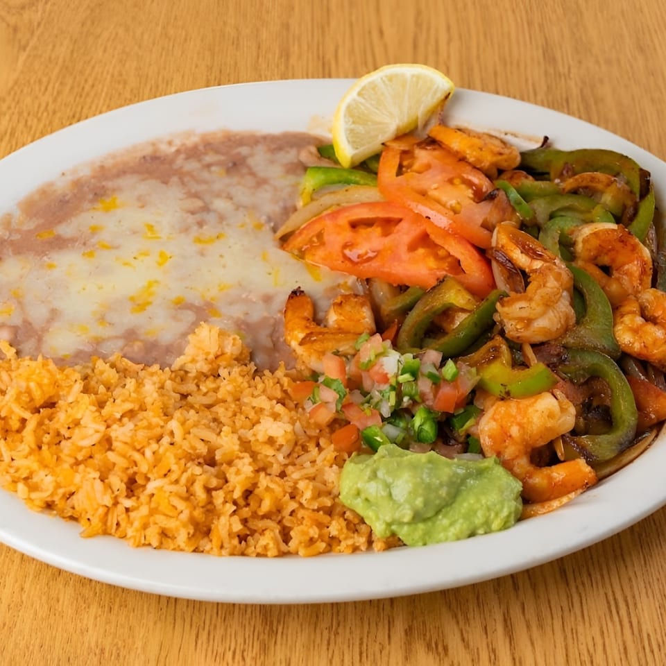 Shrimp fajitas with bell peppers, onions, rice, cheesy refried beans, guacamole, and pico de gallo.